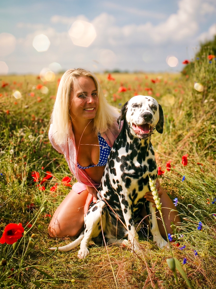 Herzliches Shooting von Mensch und Hund: Eine Frau mit ihrem Dalmatiner in einem blühenden Mohnfeld bei Rostock, fotografiert von Tempel Design