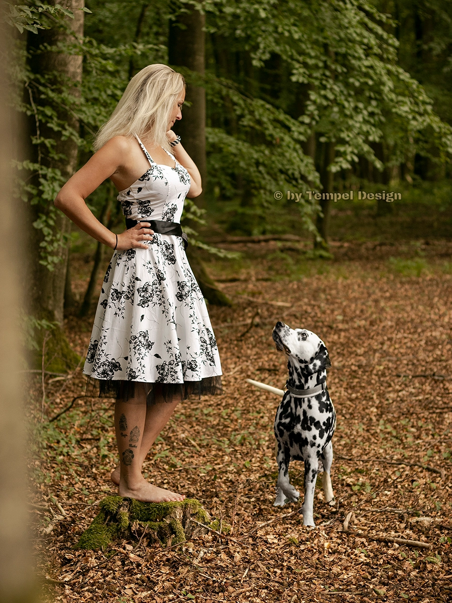 Elegantes Outdoor Shooting im Wald: Eine Frau im schwarz-weißen Kleid mit ihrem Dalmatiner in Rostock, fotografiert von Tempel Design