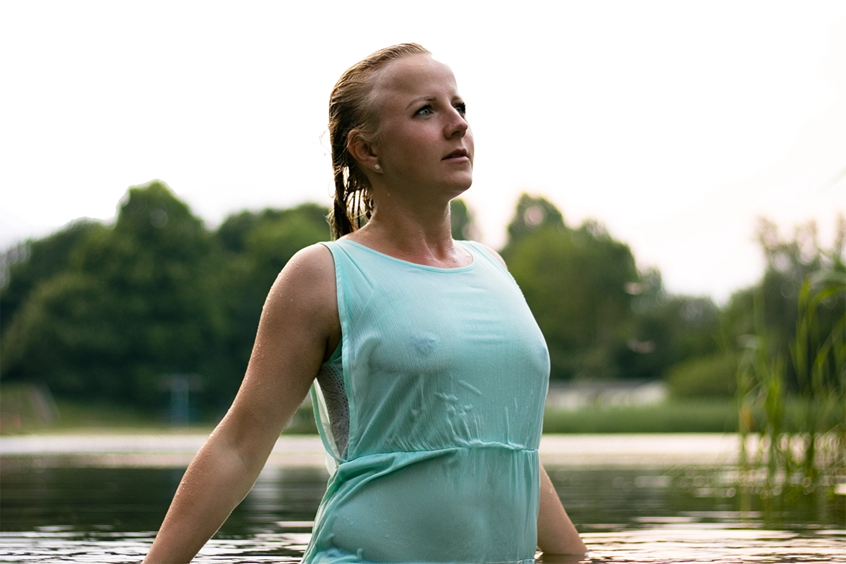 Sinnliches Wet-Look Portrait einer Frau in einem hellblauen Kleid im Wasser stehend von Tempel Design